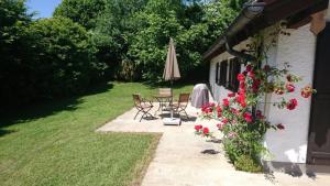 patio con tavolo, ombrellone e fiori di Ferienhaus am Chiemsee a Breitbrunn am Chiemsee