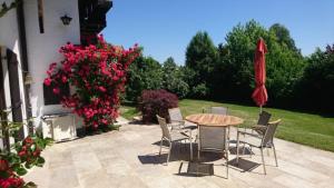 patio con tavolo, sedie e ombrellone rosso di Ferienhaus am Chiemsee a Breitbrunn am Chiemsee