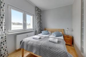 een slaapkamer met een bed met twee kussens erop bij Comfort Apartments Abrahama in Gdynia