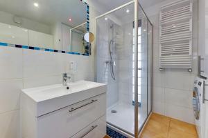 een witte badkamer met douche en wastafel bij Comfort Apartments Abrahama in Gdynia +10 foto's