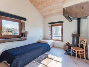 a bedroom with a blue bed and a fireplace at Gîte du Mont Gérard in La Lanterne-et-les-Armonts