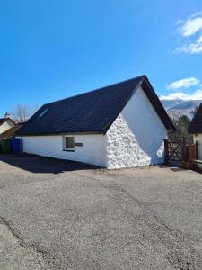 a white and black building with a black roof at The Old Post House in Fort William