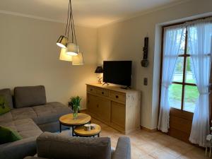Una sala de estar con un sofá y un televisor. en Ferienwohnung Theresa, en Prien am Chiemsee