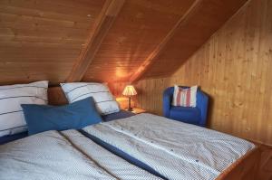 een slaapkamer met een bed en een blauwe stoel bij Birkmaase 3 Muschelblau OG in Zingst