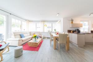 a living room and kitchen with a couch and a table at Haus Bugspriet Haegerende in Zingst