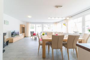 a dining room and living room with a table and chairs at Haus Bugspriet Haegerende in Zingst
