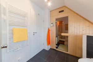 a bathroom with white walls and a wooden door at Haus Bugspriet Haegerende in Zingst +23 photos