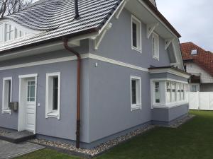 a gray house with a gray roof at Haus Bugspriet Haegerende in Zingst