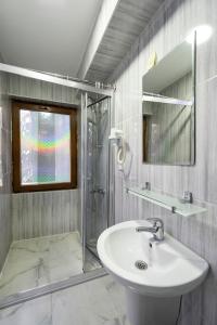 a bathroom with a sink and a shower and a mirror at Galataport suites in Istanbul