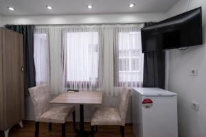 a room with a table and chairs and a television at Galataport suites in Istanbul