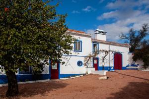 ein weißes und blaues Gebäude mit einem Hund, der davor liegt in der Unterkunft Quinta da Fortaleza in Elvas