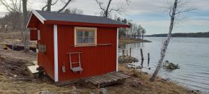 a small red house on the shore of a lake at Sankt Anna Bed and Boat, in Sankt Anna +30 photos