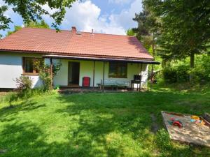 a small white house with a red roof in a yard at Ranczo Dziki Sad in Raciechowice