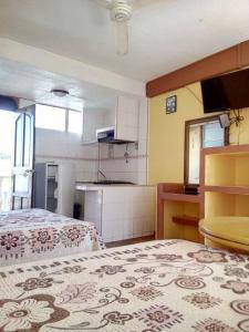 Habitación pequeña con cama y cocina en Hotel Olimar en Acapulco
