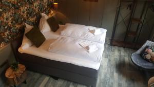 a bed with white sheets and pillows on it at Pension Abshoff in Meschede
