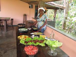 a woman standing in front of a table of food at Hotel Fazenda Pirapetinga 