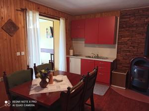 cocina con armarios rojos y mesa de comedor en Vila Pajo en Varaždinske Toplice