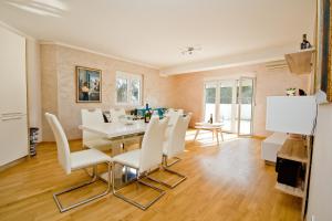a dining room with a white table and white chairs at Lux Apartment "Lea" in Kotor