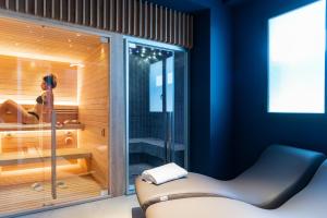 莫迪卡Modica Boutique Hotel的一间桑拿浴室,其中有一位女士坐在浴缸里