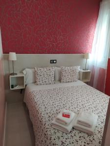 a bedroom with a large bed with a red wall at Hostal Inn Madrid in Madrid