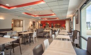 un restaurant avec des tables et des chaises ainsi qu'un bar dans l'établissement Ace Hotel Annemasse Genève, à Ville-la-Grand