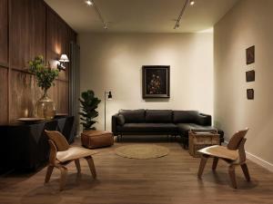 a living room with a couch and two chairs at Townhouse Apartments Maastricht in Maastricht