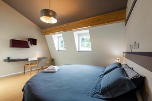 a bedroom with a blue bed and a desk at Lago Welcome Clausen II in Luxembourg