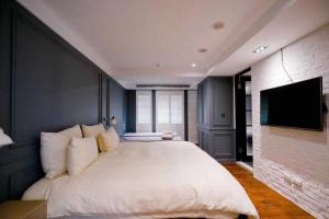 a bedroom with a large bed and a flat screen tv at 朵兒dor韓國汗蒸幕 동대문점 商務旅店 in Taipei