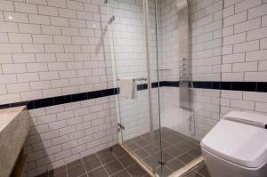 a bathroom with a glass shower with a toilet at 朵兒dor韓國汗蒸幕 동대문점 商務旅店 in Taipei