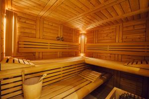 a wooden sauna with benches and a trash can at Clos Celeste - campagne d Etretat avec piscine et spa in Écrainville
