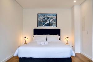 a bedroom with a white bed with two towels on it at Kubik apartments in Exclusive Virrey in Bogotá