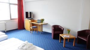 a hotel room with a bed and a desk and chairs at Plaza Inn Braunschweig City Nord in Braunschweig