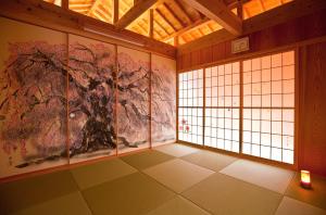 a room with paintings on the walls and a window at Yamagata Ryukyu Hatago Onna Boukairou in Onna
