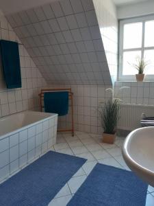a bathroom with a bath tub and a sink at Kranichrast in Zingst