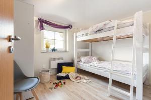 a bedroom with two bunk beds and a desk at Am Bahndamm _Haus Meerblick_ in Zingst