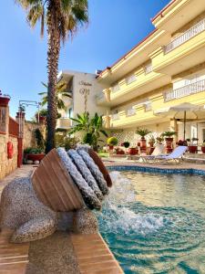 une piscine dans un hôtel avec une fontaine dans l'établissement Melis Studios, à Kallithéa Halkidikis