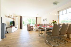 a dining room and living room with a table and chairs at Kavelweg Heimathafen in Zingst