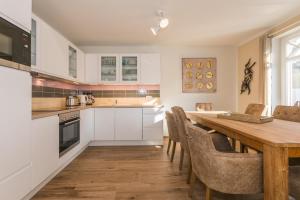 a kitchen with a wooden table and a dining room at Buten un Binnen in Zingst