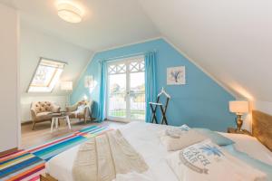 um quarto com paredes azuis e uma cama num quarto em Buten un Binnen em Zingst