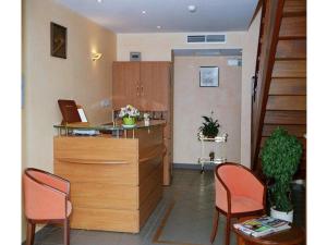 a waiting room with two chairs and a counter at Logis Hôtel Les 3B in Nouilhan