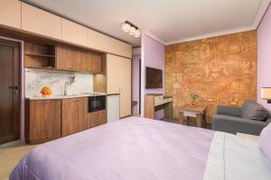 a bedroom with a large bed and a kitchen at АРТ СТУДИО СОФИЯ in Sofia