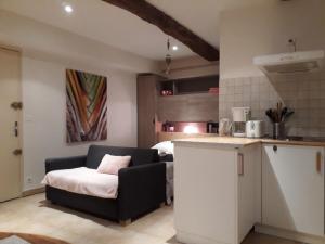 a living room with a couch and a kitchen at Les Capena 2 in Collobrières