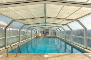 a large indoor swimming pool with glass walls at Casa Do Norte in Ovar