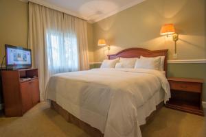 Rúm í herbergi á Hotel Villa Morra Suites