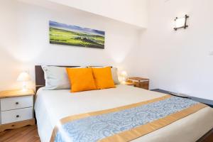 1 dormitorio con cama blanca y almohadas de color naranja en Maison Orange Florence, en Florencia