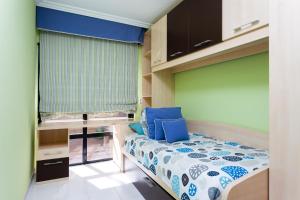 a small bedroom with a bed with blue pillows at ViVa Royal - Immense villa, unique and exclusive in Chayofa
