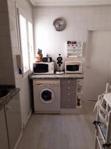 eine Küche mit einer Waschmaschine und einer Mikrowelle in der Unterkunft La Palomera in León