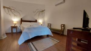 Un dormitorio con una cama con una manta azul. en Rancho da Serra Pousada, en Tiradentes
