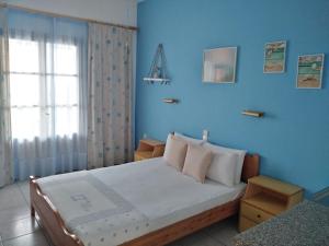 a bedroom with a bed with a blue wall at Litsa Studios in Patitiri