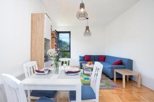 a living room with a table and a blue couch at Piskalina Apartment in Tivat